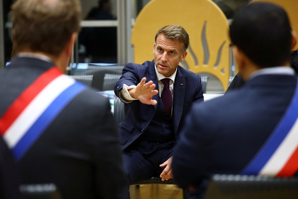 French President Emmanuel Macron meets community members at the town hall in Trappes after the shooting.
