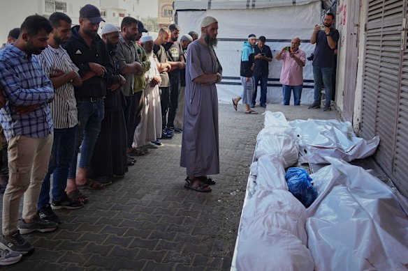 Palestinians pray over the bodies of 10 people, including several children, who were killed in an Israeli strike while they were waiting to receive nutritional supplements at a Project Hope-run medical clinic in Deir al-Balah on Thursday.