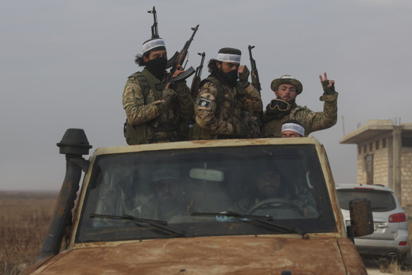 Syrian opposition fighters ride in a truck in Talhiya, Idlib countryside, Syria.