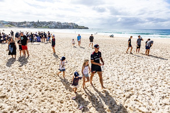 Daly Cherry-Evans takes a stroll on Bondi Beach with his daughter, Tully (white singlet).