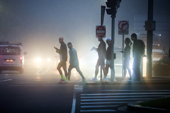 Pedestrians navigate the heavy fog blanketing the mornings this week in Melbourne.