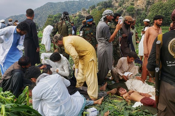 Civil defence workers, locals and army soldiers prepare to evacuate injured earthquake victims.