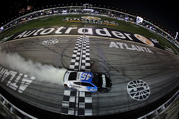 Tyler Reddick, driver of the #45 Pinnacle Toyota, celebrates with a burnout after winning the NASCAR Cup Series Autotrader 400 at Echo Park Speedway on February 22, 2026 in Hampton, Georgia. 
