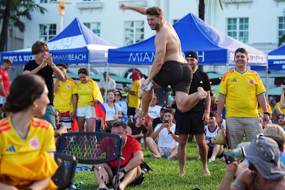 A Switzerland soccer fan leaps in the air as his team wins on penalties in their World Cup round of 16 soccer match against Colombia, Tuesday, July 7, 2026, at a public watch party in Miami Beach, Fla.