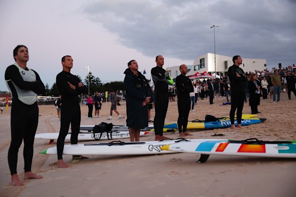 Surfers at Bondi Beach pause to remember.