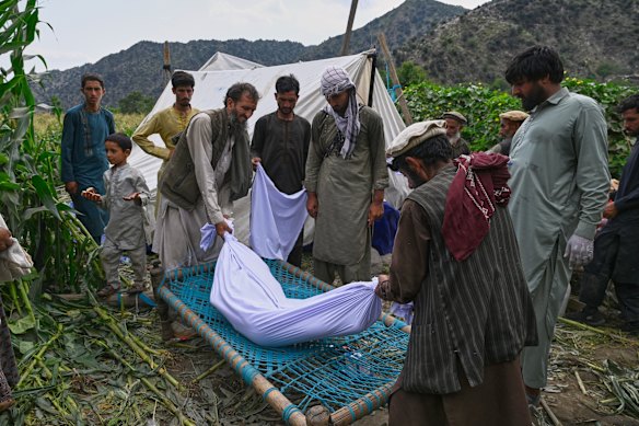 The body of a girl is placed on a bed frame after being pulled from the rubble on Tuesday, In Afghanistan, strict cultural and religious norms mean that only a close male relative – her father, brother, husband or son – is permitted to touch a woman or adolescent girl.