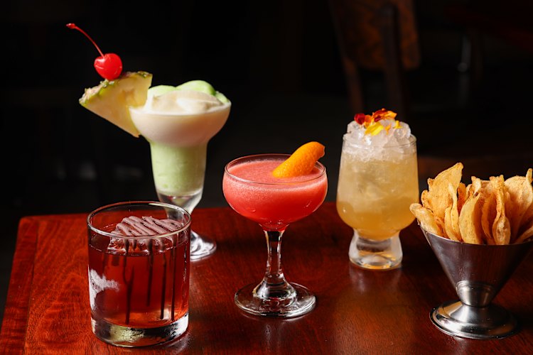  Ice Magic Old Fashioned, Midori Splice, Rhubarb Marg and Marigold Rush with a bowl of complimentary crisps.