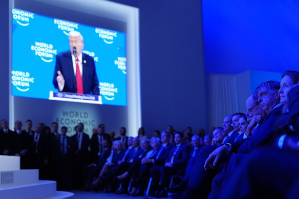 Attendees at the World Economic Forum listen to the address of US President Donald Trump.