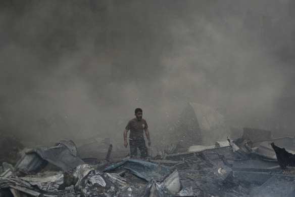 A first responder emerges through the smoke after an apartment building was struck on Wednesday,