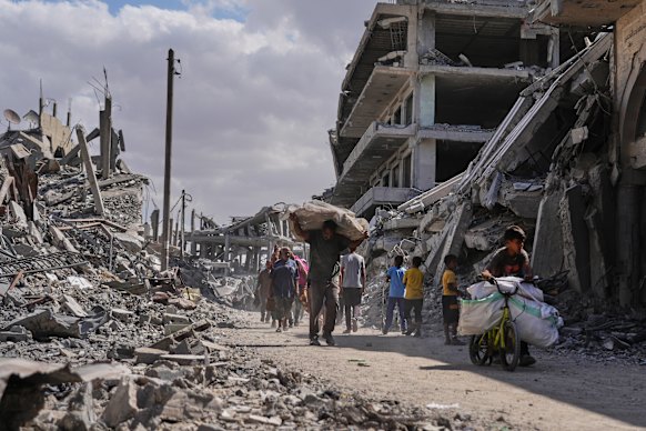 Displaced Palestinians carry belongings as they return to Khan Younis in southern Gaza.