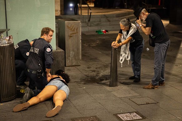 Paramedics treat one protester as others look on.