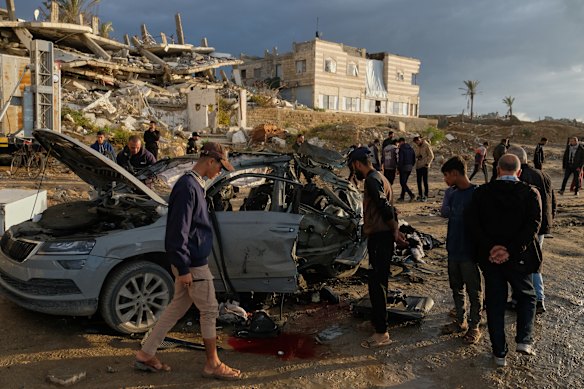 Palestinians with the remains of the car in which five people were killed by an Israeli strike in Gaza City on Saturday.
