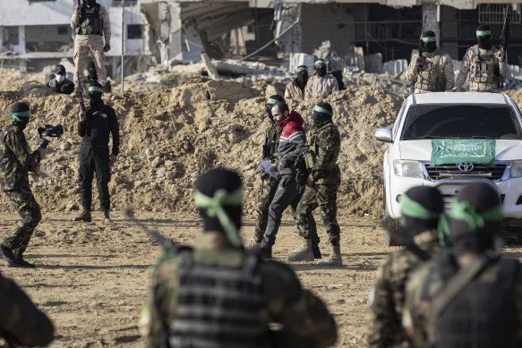  Hamas fighters escort the hostage Yarden Bibas to be handed over to Red Cross officials in Khan Younis, in the southern Gaza Strip on February 1.