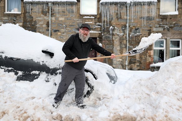 Elsewhere in Europe, a man clears a car after heavy snowfall in Dufftown, Scotland.