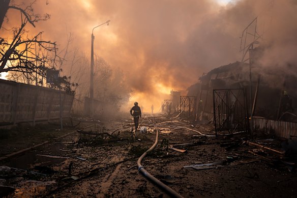 Firefighters try to put out a fire at a city marketplace following a recent Russian missile and drone attack in Kyiv.