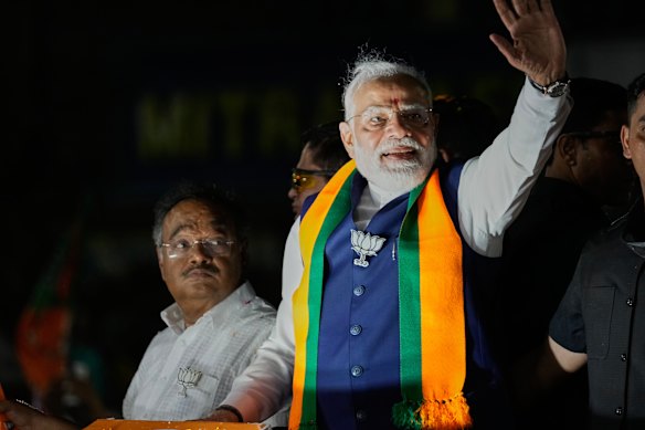 Modi waves to supporters at an election roadshow in West Bengal.