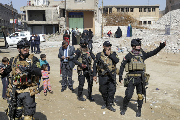 Iraqi security officials clear the road before the car carrying Pope Francis leaves the square where he led a prayer session in Mosul, once the de-facto capital of Islamic State.