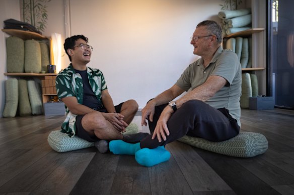 A program connecting international students and retired Melburnians designed to combat loneliness.  Indonesian student Arie Judanto chatting with Wayne Pash 72 after doing yoga together. 
