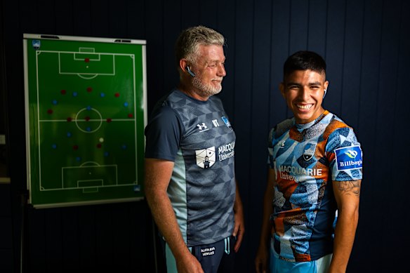 Sydney FC player Piero Quispe with coach Ufuk Talay and the translation earpieces.