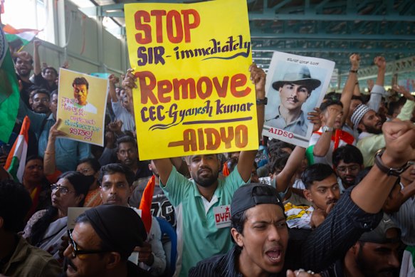 People wave placards and shout slogans as they participate in a protest demanding the resignation of Chief Election Commissioner Gyanesh Kumar over alleged voter-roll irregularities in Bengaluru, India. 