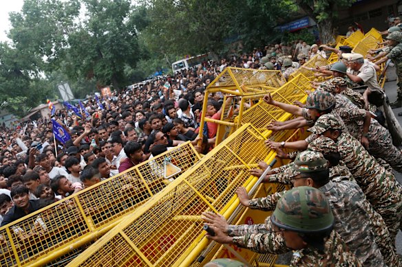 Supporters of the Cockroach Janta Party push against a barricade as they attempt to march to India’s Parliament, demanding the resignation of the education minister, in New Delhi.