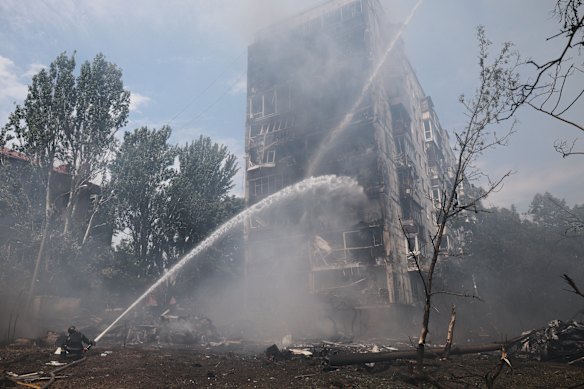 Rescue workers try to put out a fire of a residential building burning after a Russian air guided bomb strike in Zaporizhzhia, Ukraine.