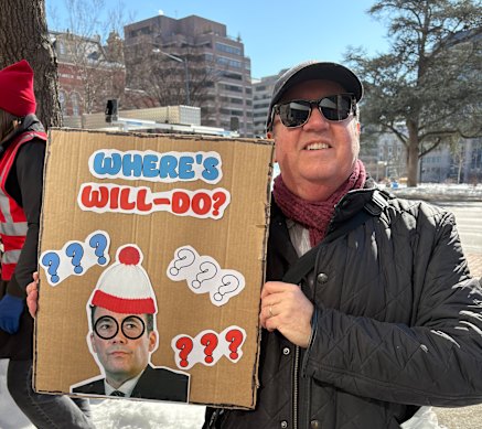 John Kelly, who left the paper two years ago, with a sign querying the absence of Washington Post publisher William Lewis.