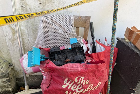 A small toy truck poking out of a shopping bag outside the Legian bungalow where Australian Damien John Shaw killed his two kids and himself on Sunday. 