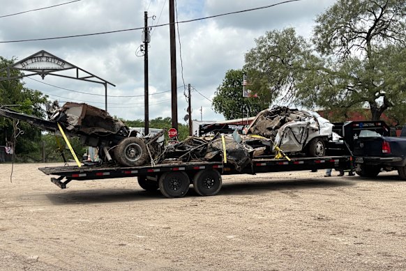A smashed-up vehicle is removed from the riverbank in Ingram, just outside Kerrville, following the Texas floods.