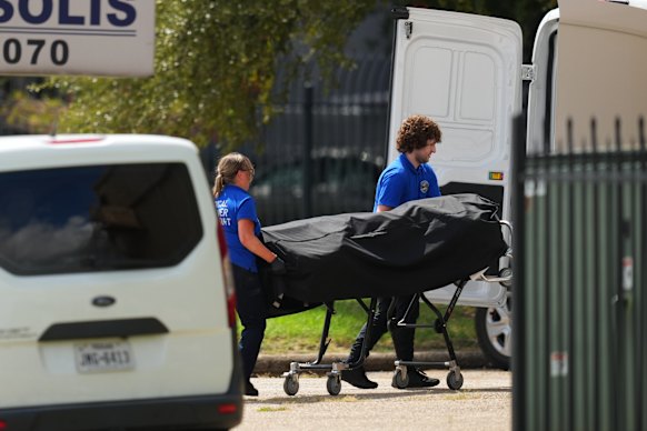 The body of the shooting suspect is placed in the medical examiners van.