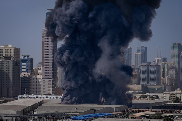 A black plume of smoke rises from a warehouse at the industrial area of Sharjah City near Dubai.