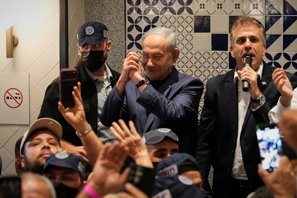 Israeli Prime Minister Benjamin Netanyahu, leader of the Likud party, gestures to supporters as he visits a shopping centre in Holon during his campaign.
