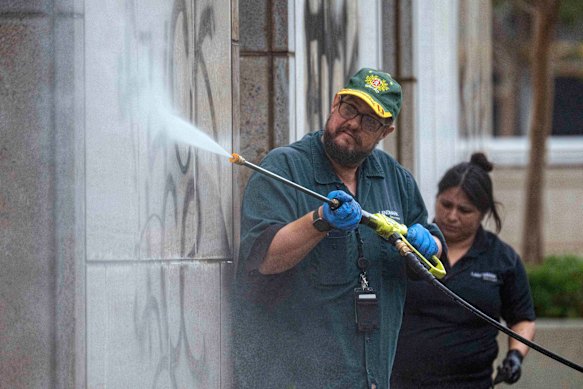 Workers remove graffiti from the Ronald Reagan Federal Building and Courthouse in Santa Ana.