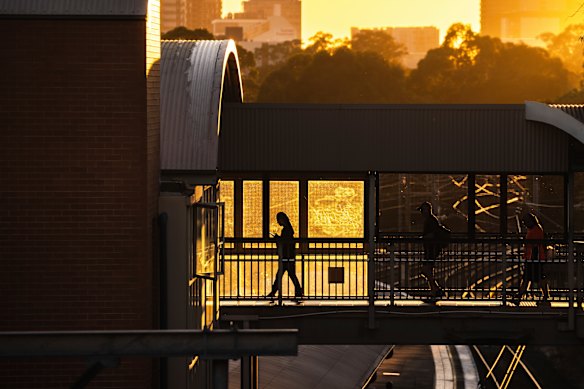 The sun rises over commuters at Westmead railway station during the Sydney heatwave on Thursday.