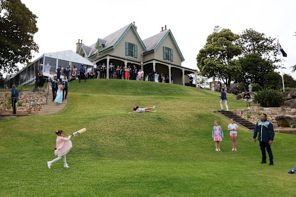 Usman Kawaja bowls to daughters Aisha and Ayla on the lawn at Kirribilli House.