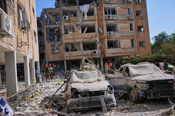 Israeli security forces inspect a destroyed building hit by a missile fired from Iran, in Holon, near Tel Aviv.