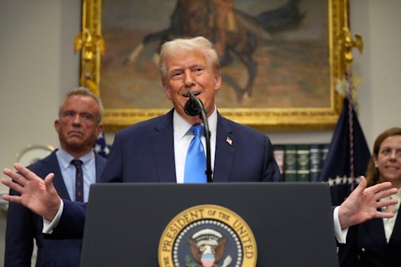 US President Donald Trump in the White House on Monday, as Health Secretary Robert F. Kennedy Jr (left) watches.