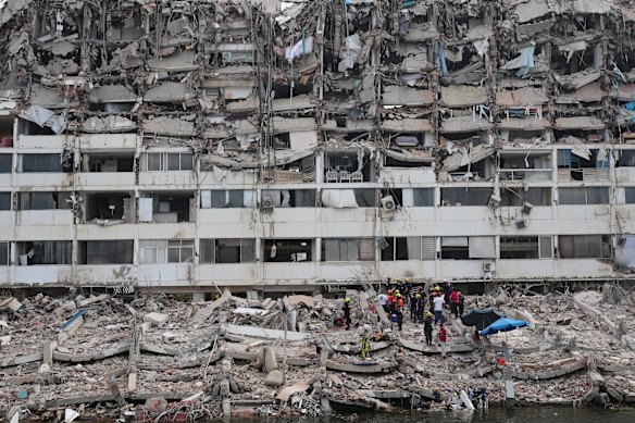 Rescue workers search through rubble from a partially collapsed building in La Guaira. 