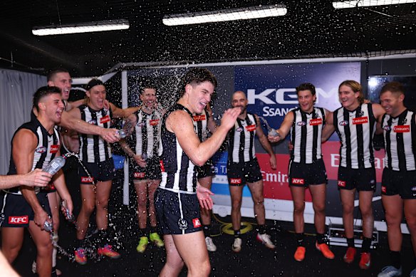 The Pies get around debutant Charlie West as they sing the song after a hard-earned win.