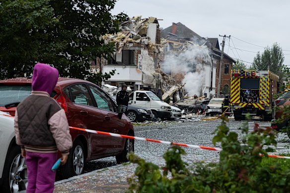 A child watches firefighters work at homes destroyed by a Russian strike on September 28 in Kyiv.