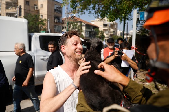 A dog is reunited with its owner after being rescued from a building damaged during Iran’s retaliatory strikes this morning.