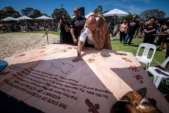 Mutti Mutti and Wamba Wamba man Jason Kelly puts his hand print on the kangaroo-skin treaty document.