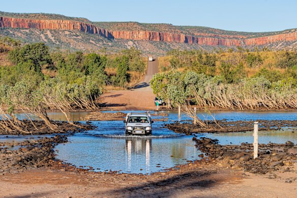 A four-wheel-drive vehicle traverses the iconic Pentecost Crossing, Gibb River Road, in the Kimberley.