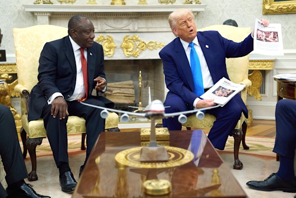 President Donald Trump shows South Africa’s President Cyril Ramaphosa stories about white farmers who were victims of crime, during their Oval Office meeting.