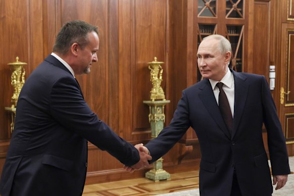 Putin, right, shakes hands with newly appointed Acting Transport Minister Andrey Nikitin on Monday.