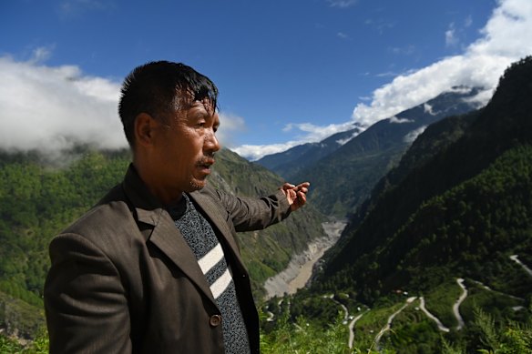 Pasang Tamang stands where he witnessed his home, Syabrubesi, being swept away by flash flooding in Nepal. 