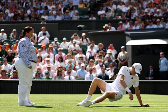 Chair umpire Alison Hughes checks on Sinner after his second fall of the match.