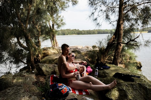 Jacob Scott and Angel Balzke, from Fairfield, bre the oppressive heat with a picnic on the Georges River on Wednesday.