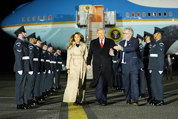 US President Donald Trump and first lady Melania Trump are greeted by The Viscount Hood, Lord-in-Waiting, centre, right, as they arrive at Stansted Airport near London on Tuesday (Wednesday AEST). 