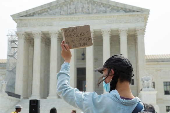 An Asian-American supporter of affirmative action protests outside the US Supreme Court a day after it struck down race-conscious admissions programs.